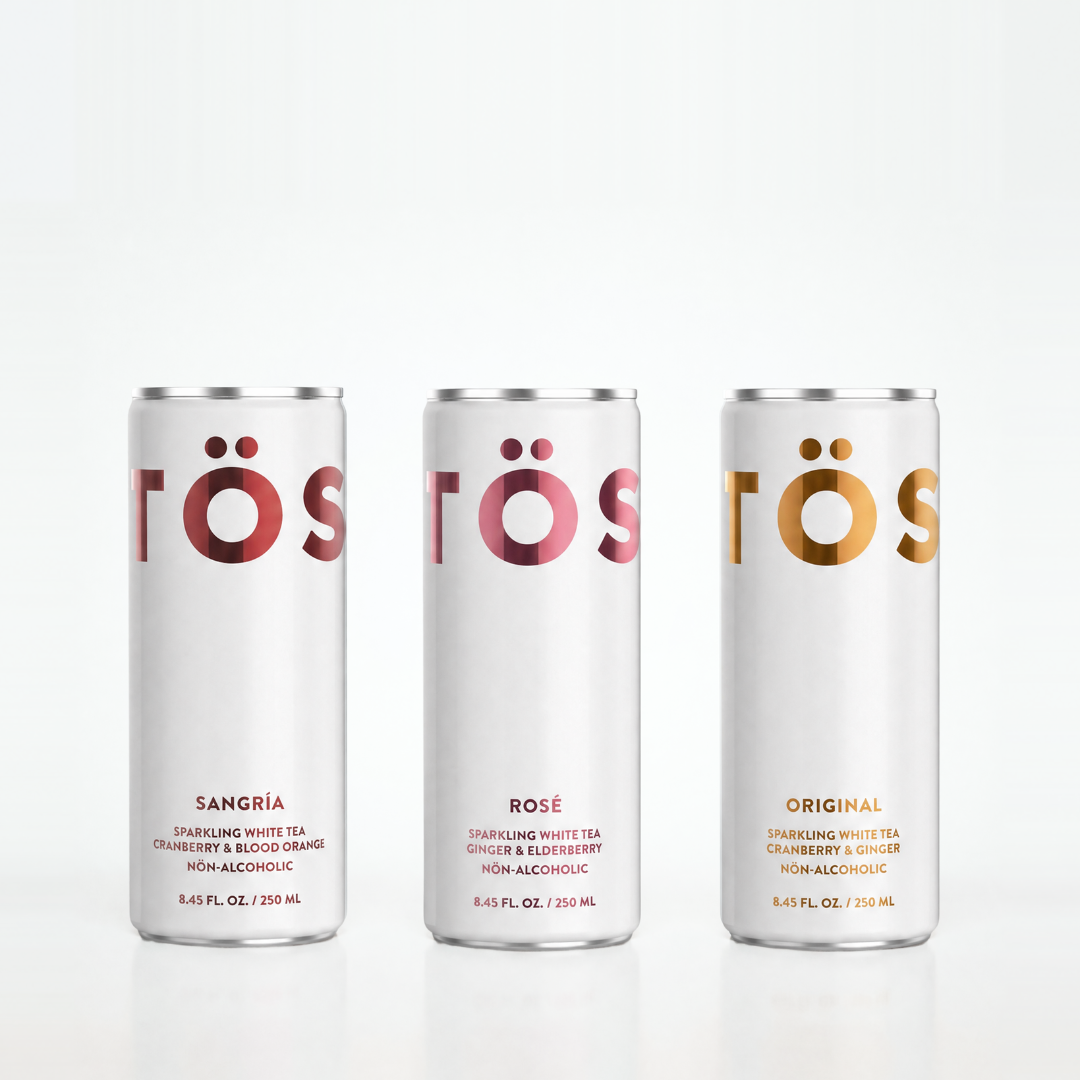 Three cans of Töst drinks with different flavors on a white background
