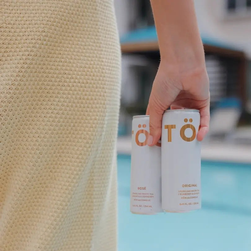 TÖST Original non alcoholic sparkling beverage cans by the pool
