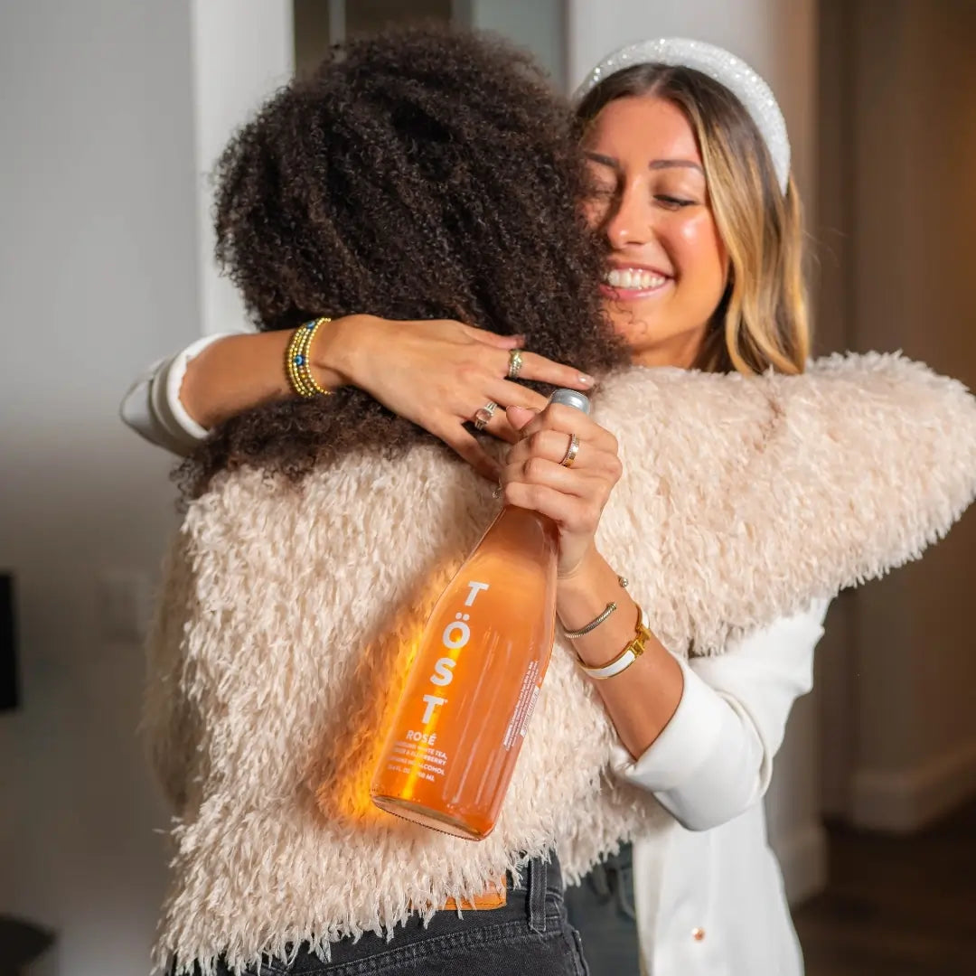 Friends enjoying TÖST Rosé non alcoholic sparkling beverages together
